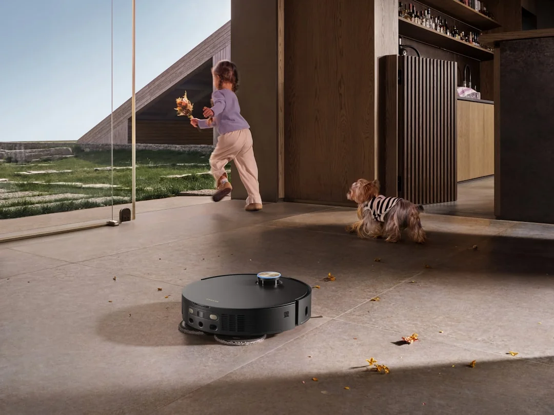 A professional cleaner in protective gear vacuuming the floor in a modern living room.